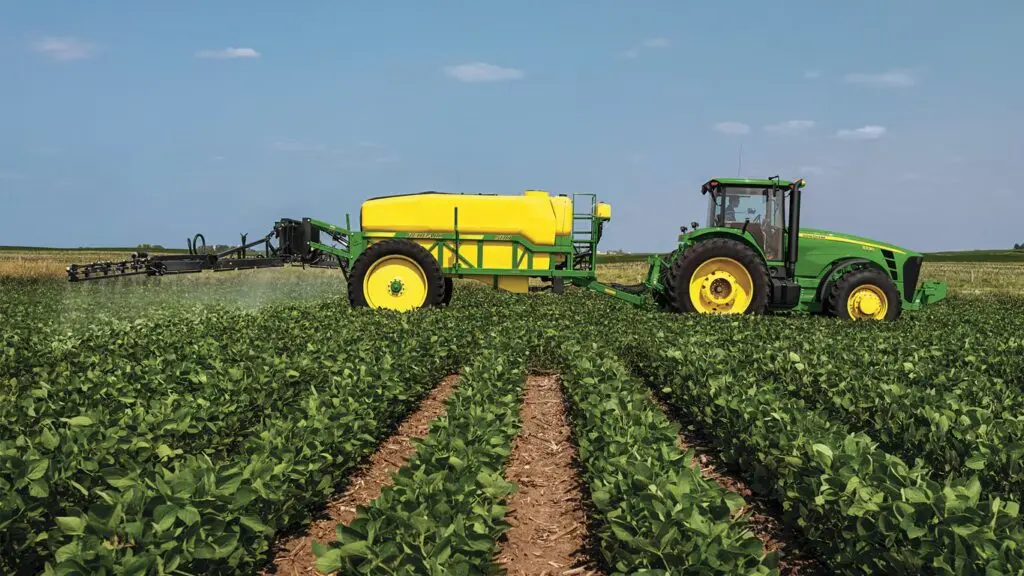 Tractor John Deere con pulverizadora aplicando insumos con controlador de dosis GreenStar
